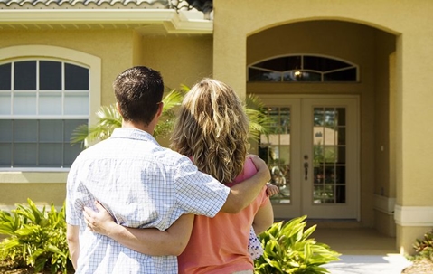 couple standing in front of new home